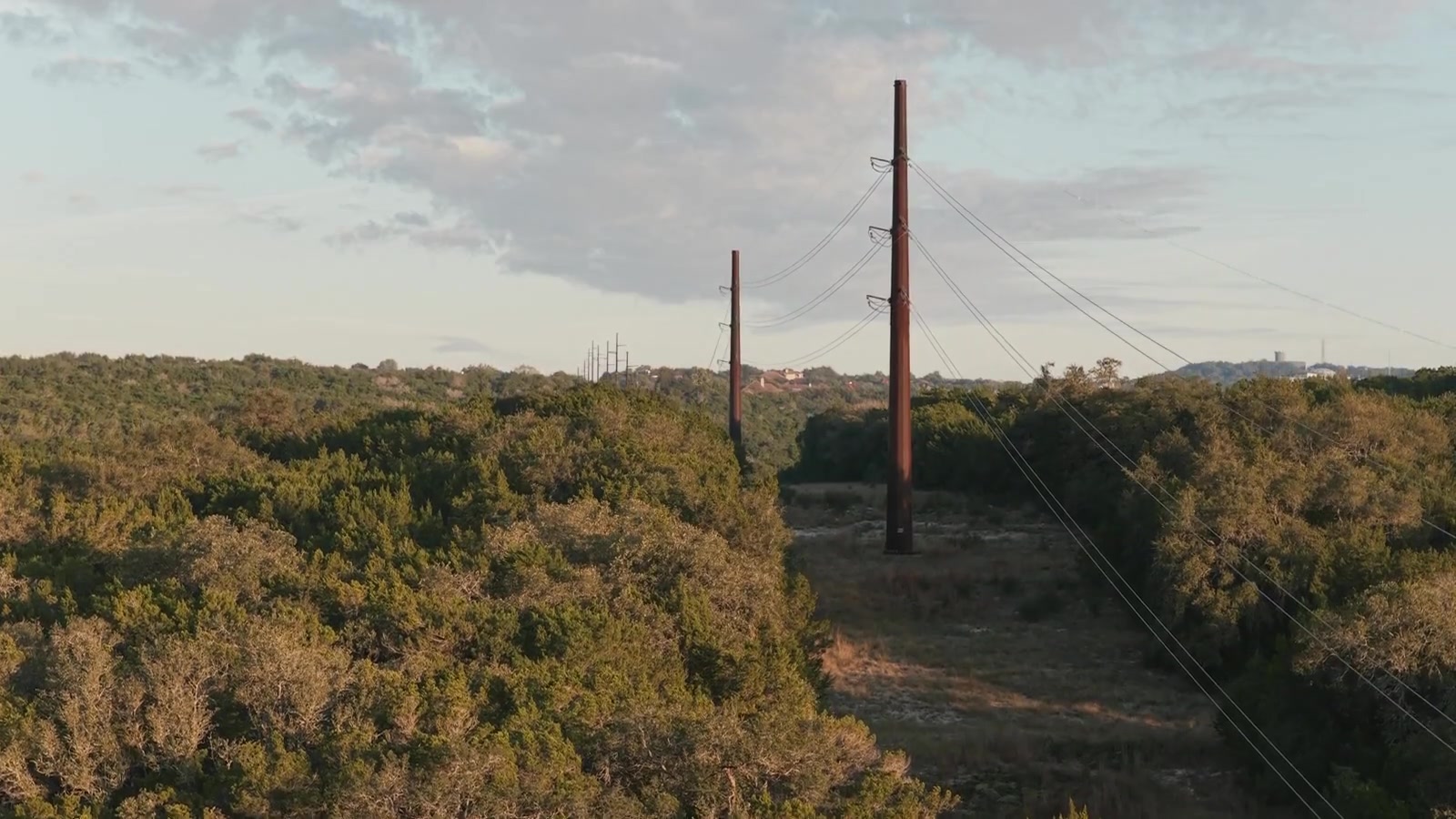 Aerial view of utility poles and vegetation along a corridor