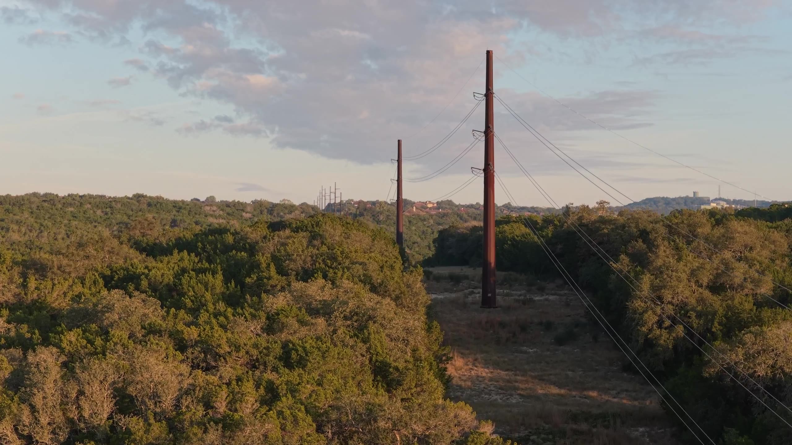 Aerial view of transmission lines through a wooded corridor